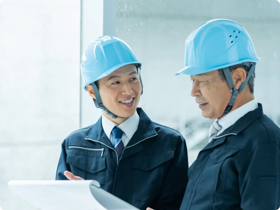 上司に工事の進捗報告をする従業員